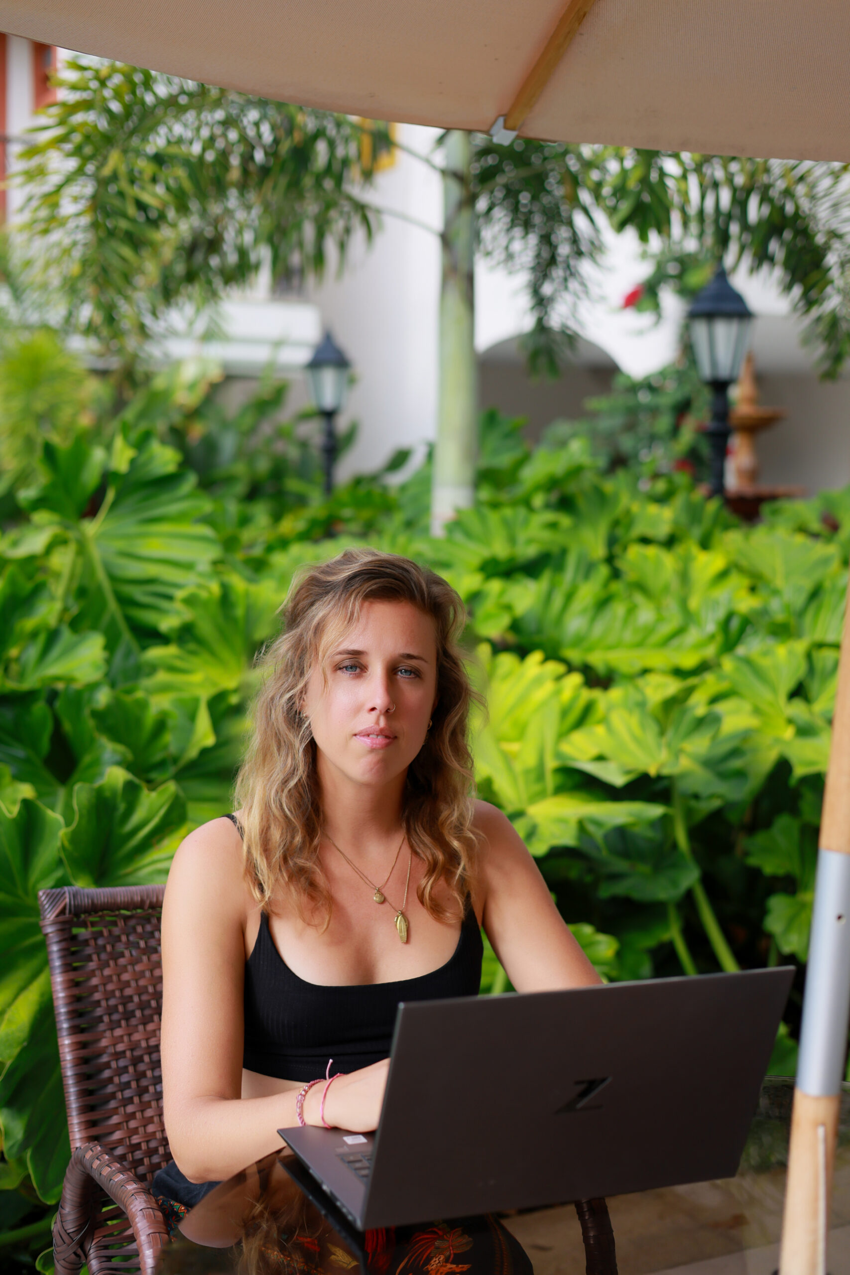 Luciënne Bregman working on her laptop in a tropical garden